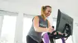 Smiling woman rides Peloton Bike