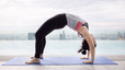 Woman practices wheel pose outdoors