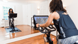 Woman rides Peloton Bike at home