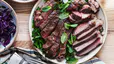 A plate of cooked steak cut up and arranged on a plate with greens. Learn how much protein is too much in this article.