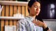 A woman breathing out through her mouth while practicing cyclic sighing. Her hand is resting on her chest.