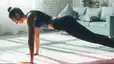 Side view of a woman about to do a push-up at home.