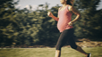 Woman running while pregnant outside 