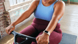 Woman smiling while doing a rowing machine workout on the Peloton Row