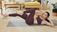 Woman working out at home doing the bicycle crunch as an oblique exercise
