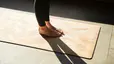Close up of a woman's feet on a yoga mat while doing ankle mobility exercises