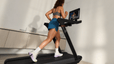Woman doing a HILIT workout on her Peloton Cross Training Tread.