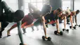 Group of people at gym do renegade row exercise, an example of a dumbbell triceps exercise 