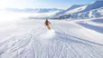 Person skis on a snowy ski slope 