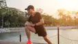 Man stretching outside in morning sunlight as part of marathon strength training