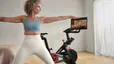 Woman doing a yoga cross training workout at home with her Peloton Bike.