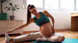 Pregnant woman stretches at home