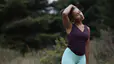 Woman stretches neck outdoors 