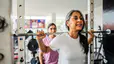 Woman squatting a barbell to build strength while exercising during menopause.