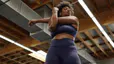 Woman stretches at the gym; stretching can be part of a deload week