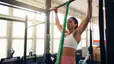 Young woman at the gym performing the lat exercise resistance band pull-ups while doing a lat strength workout.