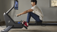 Man does a Peloton Row workout at home