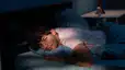 A man lying awake in his bed. He can't sleep after exercising.