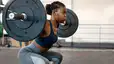 Woman in the gym doing barbell squats with heavy weights