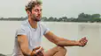 A man meditating outside to strengthen his mind-body connection.
