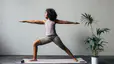 Woman practices Warrior 2 Pose during a yoga for athletes practice