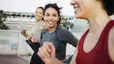 A group of three women practicing social wellness by going on a power walk outside together.