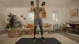 Man holds dumbbells while doing hamstring exercises during a Peloton strength workout at home