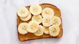 Peanut butter and banana toast, pictured here on a white marble countertop, is a great food to eat before a workout.