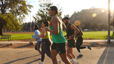 A local fitness club going for an outdoor run together at a park.