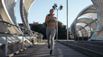 Woman running through city bridge