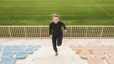 A woman running up a flight of stairs at an outdoor stadium.