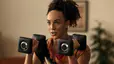 Woman holds two dumbbells 