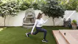 Woman does a walking lunge outdoors on grass