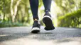 A close-up photo of a person walking outside while wearing black walking shoes and leggings. Learn how to treat and prevent blisters in this article.
