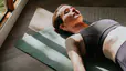 Woman rests in Savasana, a heart-opening yoga pose