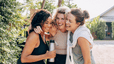 Three women embracing each other outside
