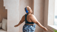 A woman dancing while wearing exercise clothes and headphones.