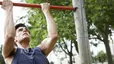 Man doing a reverse pull up exercise outdoors