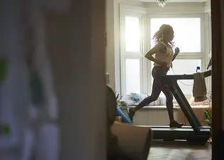 Peloton member running on a Peloton Tread indoors