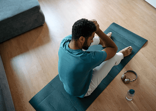 Tired man sitting on a yoga mat