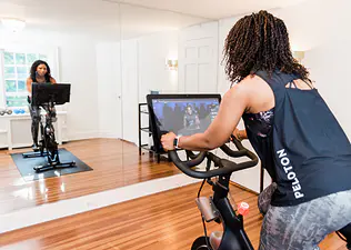 Woman rides Peloton Bike at home