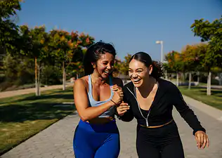 Two women exercising and laughing outside