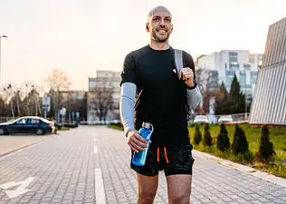 A man with confidence and high self-esteem walking outside after a workout.