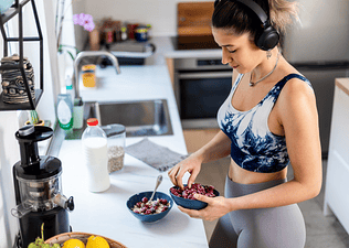 A woman preparing a bowl of fruit before going on a ride as part of her cycling nutrition strategy.