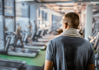 Back view of a man looking around the gym.