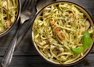 Overhead photo of a plate of basil fettuccine with grilled chicken, which is generally a good thing to eat the night before a race.