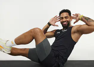 Peloton instructor Rad Lopez doing bicycle crunches on a white background
