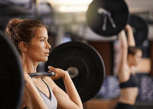 Woman lifts a heavy barbell, one rep max 