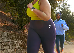 Woman running outside with a run group while training for a 5K.