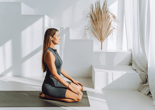 Woman practices Hero Pose in yoga